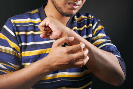 man suffering from itching skin, close up.の写真素材