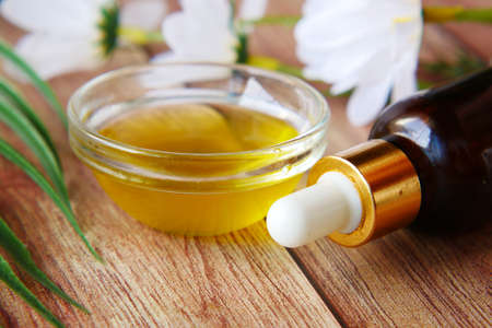 pipette and oil in a small container on tableの写真素材