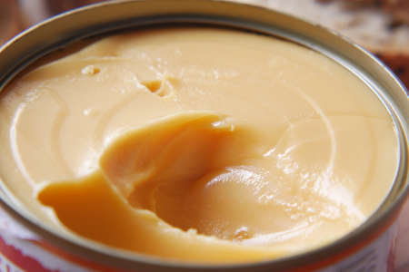 cheddar cheese in a tin container on tableの写真素材