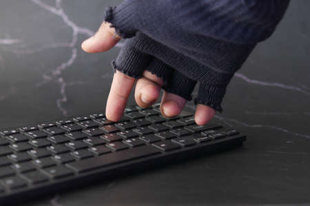 hacker hand stealing data from laptop top downの写真素材