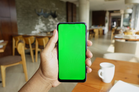 Close up of young man hand using smart phone with green screenの写真素材