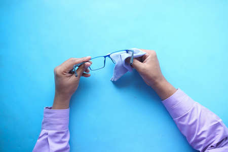 cleaning eyeglass with tissue close upの写真素材