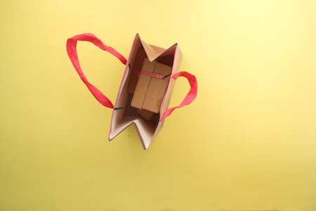 gift box in a shopping bag on yellow background