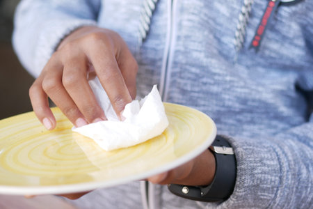 close up of young man wiping plate with a cloth