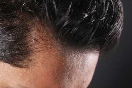 hair loss concept with man checking his hairの写真素材