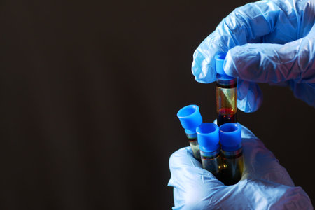 hand in blue medical gloves holding blood test tube with copy spaceの写真素材