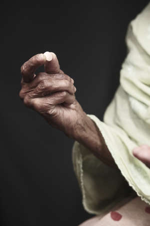 senior women taking medicine isolated on blackの写真素材