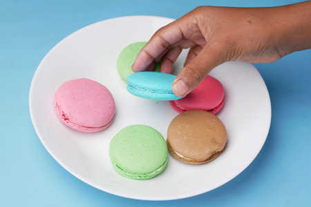 Close up of macaroon on blue background with copy space