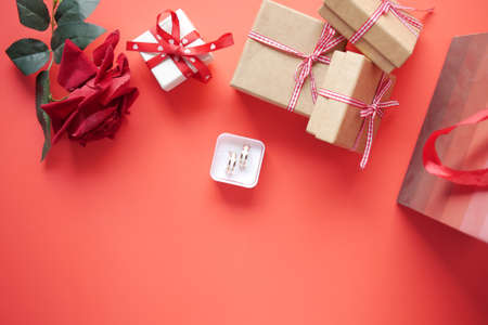 wedding ring and gift box and rose flower on redの写真素材