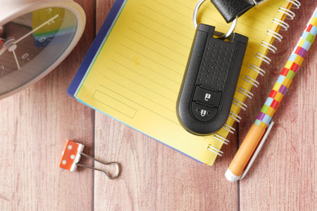 notepad, clock and car key on tableの写真素材