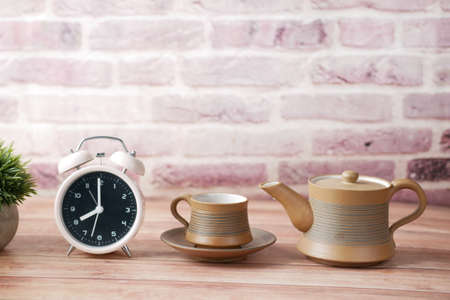 tea cup and table clock on tableの写真素材