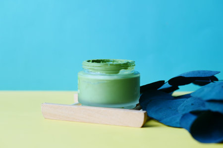 bubble clay mask in container on color background