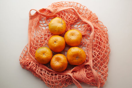 fresh orange fruit in a shopping bag on tableの写真素材