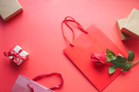 Top view of gift box and rose flower on red backgroundの写真素材