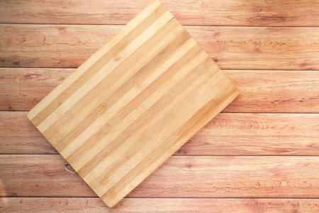 wooden chopping board on wooden background top down