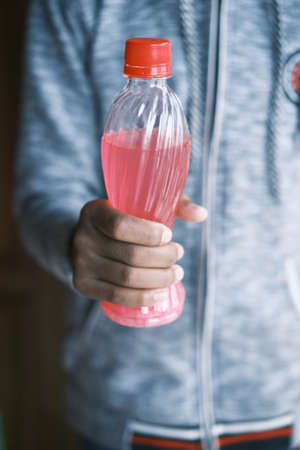 men holding a bottle of soft drinksの写真素材