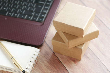 stack of cardboard parcels and laptop on tableの写真素材