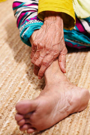 Close up on senior women feet and hand massage on injury spot.の写真素材