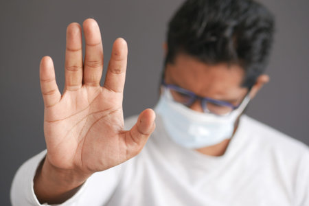 A young asian man with protective mask in face feeling sad