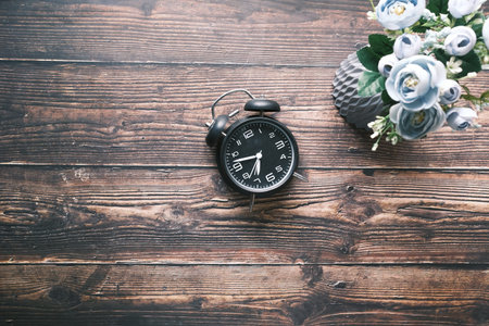 old alarm clock on wooden table top view