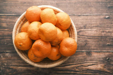 many orange fruits in a bowl on tableの写真素材