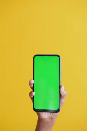 Close up of young man hand using smart phone with green screenの写真素材