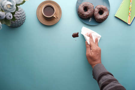 top view of person hand cleaning chocolate spilling with tissueの写真素材