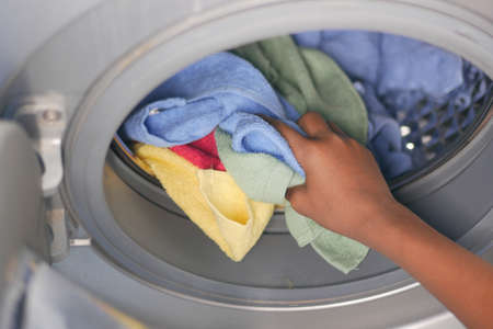 putting towel and cloths in a washing machine.の写真素材