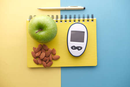 diabetic measurement tools, almond nuts, apple on color backgroundの写真素材