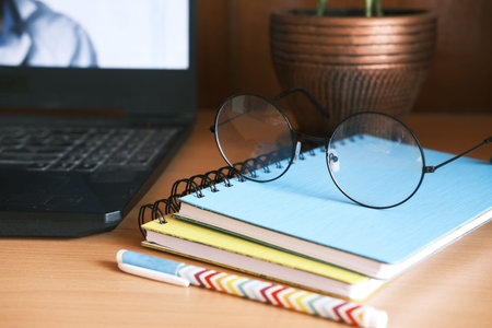 close up of notepad, pen and laptop on table