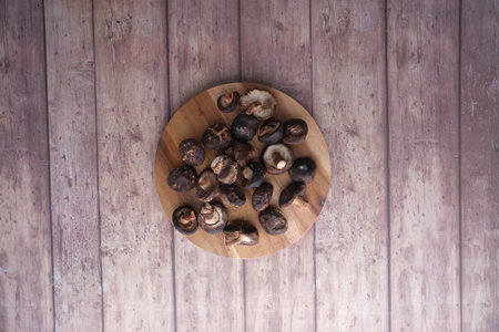 raw champignon mushroom on a chopping board on table