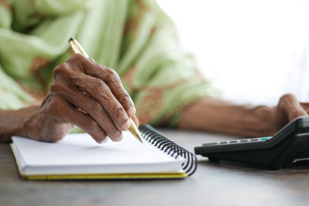 Close up of senior women hand writing on notepad.
