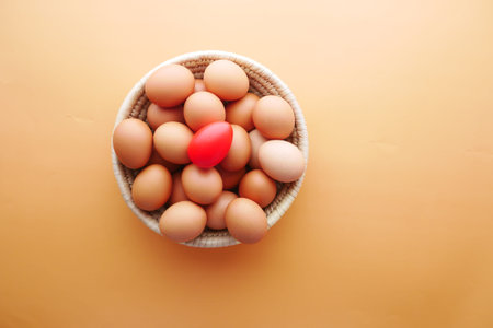 top view of eggs in a bowl on orange background