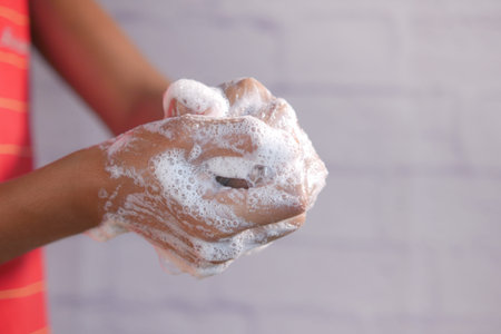 young man washing hands with soap warm water