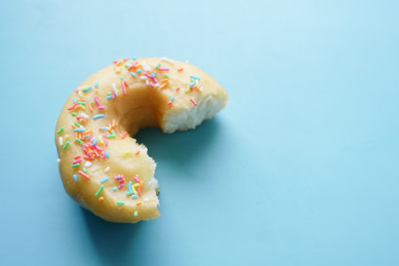 half eaten donuts on blue backgroundの写真素材