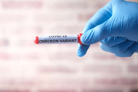 hand hold omicron variant corona virus blood test tubeの写真素材