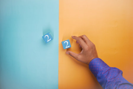 number two on wooden block on blue backgroundの写真素材