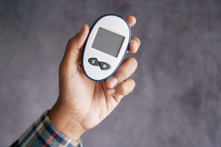 mans hand measuring blood sugar levelの写真素材