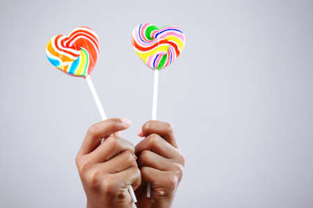 hand holding lollipop candy on white backgroundの写真素材