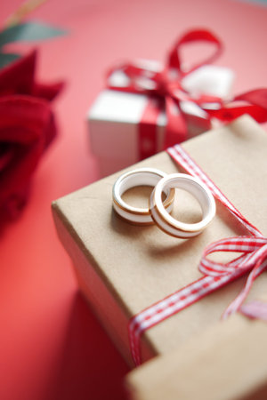 wedding ring and gift box and rose flower on redの写真素材