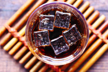 cold soft drinks and ice in a glass on tableの写真素材