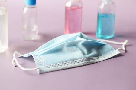 Surgical masks, and hand sanitizer on orange background