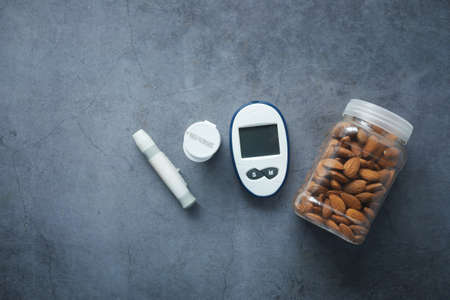 diabetic measurement tools and almond nut on black backgroundの写真素材