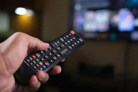 close up of man hand holding tv remote.の写真素材