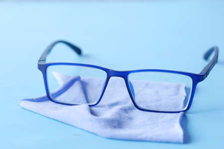 blue color eyeglass and cleaning cloths on tableの写真素材