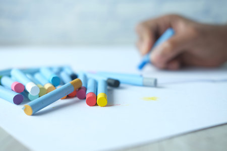 Color pencils on yellow papers on table