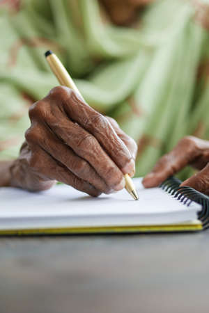 Close up of senior women hand writing on notepad.の写真素材