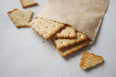 close up of sweet cookies spilling form a paper packet on table