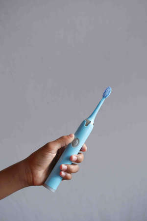 holding a blue color electronic toothbrushesの写真素材