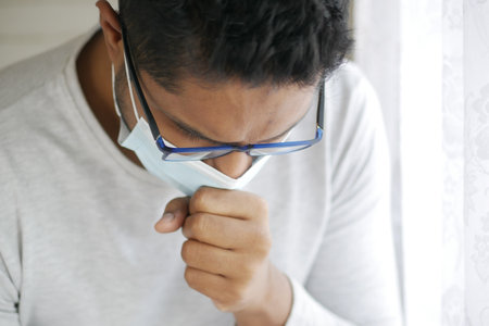 Sick man got flu allergy sneezing and blowing noseの写真素材